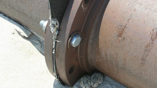 Two tern chicks hiding in the shade under a pipe